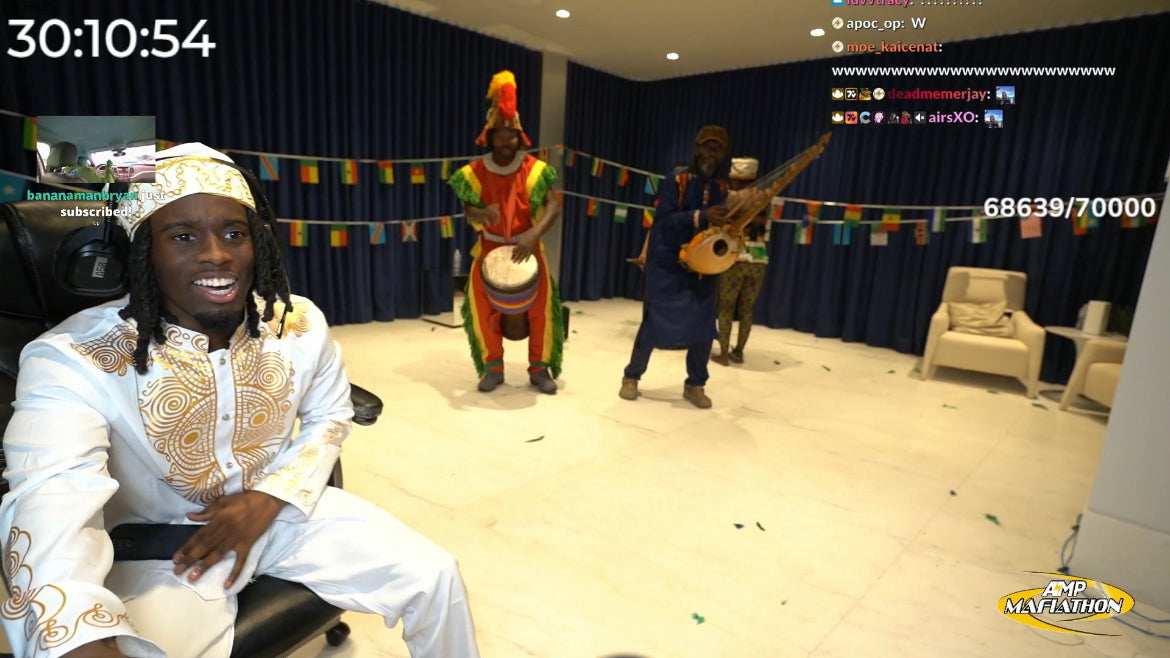 Kai Cenat sits in his chair while a group of instrumentalists surprise him with a song during his subathon.
